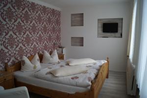 a bedroom with a bed with white pillows and a tv at Hotel Am Kurpark in Bad Suderode