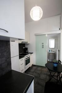 eine Küche mit weißen Schränken und einer schwarzen Arbeitsplatte in der Unterkunft Romantic and cosy apartment in Athen