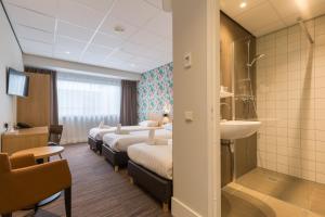 een hotelkamer met 4 bedden en een wastafel bij Best Western Amsterdam in Amsterdam