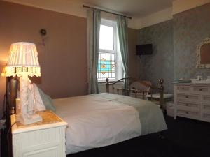 a bedroom with a bed with a lamp and a dresser at Manor View in Whitby