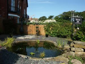 a small pond in a yard next to a house at Manor View in Whitby