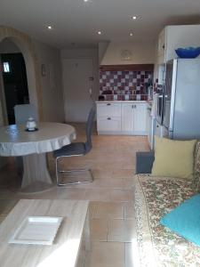 cocina y sala de estar con mesa y nevera en Appartement en bord de mer en Port-la-Nouvelle