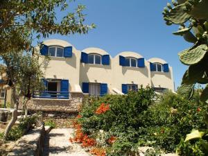 a building with blue windows and a garden at Sea Bliss Villas in Karterados