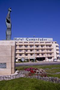 un edificio con una estatua delante de él en Hotel Comendador, en Bombarral