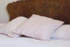 two pillows on a bed with a wooden head board at Casa Liliana in Marsala
