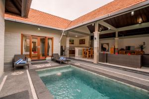 a house with a swimming pool in the backyard at Taman Bali Villas in Legian