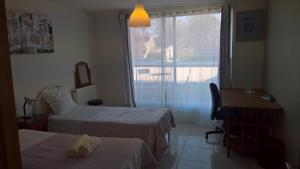 a hotel room with two beds and a desk and a window at Bambou & Olivier Chambres in Roubaix +21 photos