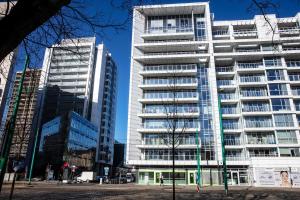 a tall building in a city with two tall buildings at Apartamenty I.M.A Towarowa in Poznań
