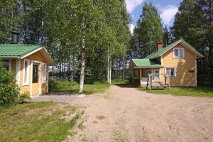 ein Haus mit einem Feldweg neben einem Haus in der Unterkunft Mäkelän Lomatuvat Cottages in Korkeakoski