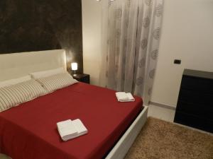 - une chambre avec un lit rouge et 2 livres dans l'établissement Spirduta di Levante, à Syracuse