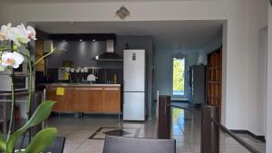 a kitchen with a refrigerator and a table in it at Bambou & Olivier Chambres d'Hôtes in Roubaix