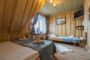 1 dormitorio con 2 camas en una habitación con paredes de madera en Agrotatry U Stachy, en Bukowina Tatrzańska