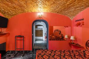 リヴィウにあるApartment Masoch Styleのオレンジ色の壁の客室と廊下(ベッド2台付)