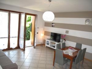 ein Wohnzimmer mit einem Tisch und einem TV in der Unterkunft In vacanza da Miki 01 in Desenzano del Garda