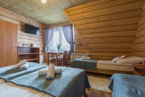 a bedroom with two beds and a table with a chair at Agrotatry U Stachy in Bukowina Tatrzańska