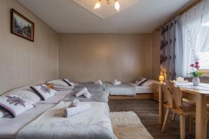 ブコビナ・タトシャンスカにあるAgrotatry U Stachyのベッド3台、テーブル、ダイニングルームが備わる客室です。