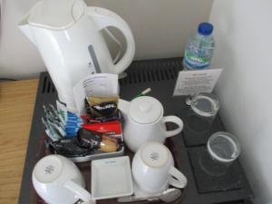 a kitchen counter with a coffee mug, coffee maker, and other items at Gate Lodge Guest House in Hunstanton