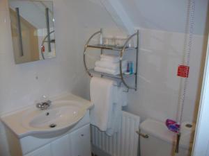 Baño blanco con lavabo y aseo en Gate Lodge Guest House en Hunstanton