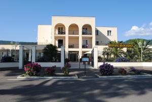 a white building with flowers in front of it at Hotel Holiday Sul Lago in Bolsena