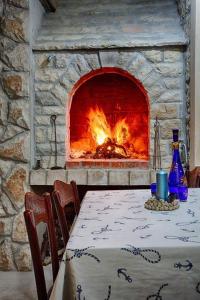 a table and a fireplace with a table and chairs at Ul. Ivana Farolfija 12 Apartman Domina in Vis