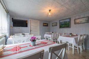 a dining room with white tables and white chairs at Agrotatry U Stachy in Bukowina Tatrzańska