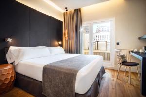 a hotel room with a large bed and a window at Catalonia Gran Vía Madrid in Madrid