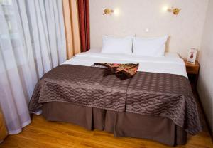 Cette chambre comprend un lit avec une couverture brune. dans l'établissement Hotel Rus, à Irkoutsk