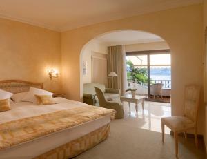 um quarto de hotel com uma cama e uma varanda em Boutique Hotel La Rocca em Ronco sopra Ascona