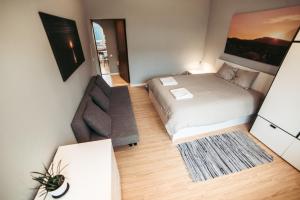 a small bedroom with a bed and a couch at 40 Saules in Ventspils