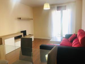 a living room with a red couch and a window at Apartamento Puente Romano Portal 4 1-B in Salamanca