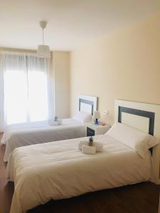 - une chambre avec 2 lits avec des draps blancs et une fenêtre dans l'établissement Apartamento Puente Romano Portal 4 1-B, à Salamanque