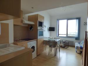 una cucina e una sala da pranzo con tavolo e sala da pranzo di Les Voiles D'Olona, vue sur le port de plaisance a Les Sables-dʼOlonne