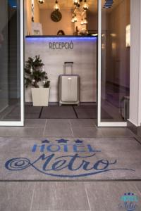 ブダペストにあるホテル メトロのスーツケースを持つドア前の床の看板