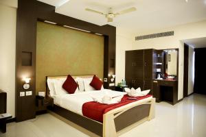 a bedroom with a large bed with red and white pillows at Hotel Rockfort View by Park Elanza in Tiruchirappalli +19 photos
