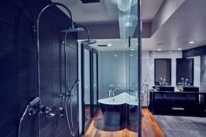 a bathroom with a shower, sink, and tub at Malmaison Belfast in Belfast