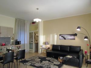 un soggiorno con divano nero e tavolo di Roby's House Casa Vacanze - Affiliato Best-Incoming a Viadanica Colognola