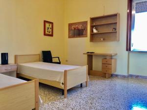 ガラトーネにあるAppartamento Cavourのベッドルーム1室(ベッド2台、デスク付)