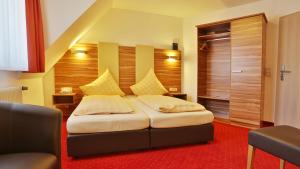 sypialnia z łóżkiem z czerwonym dywanem w obiekcie Hotel KRONE Garni w mieście Deckenpfronn