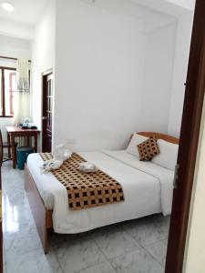 a white bedroom with a bed and a table at Otha Shy Airport Transit Hotel in Katunayake