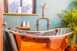 eine Badewanne in einem Badezimmer mit Waschbecken in der Unterkunft 3 MASONS COURT The Oldest House in Stratford Upon Avon, Warwickshire. in Stratford-upon-Avon