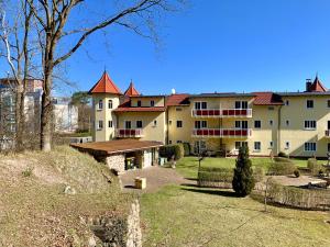 a large white building with red roofs at Hotel Dünenschloss in Ostseebad Karlshagen