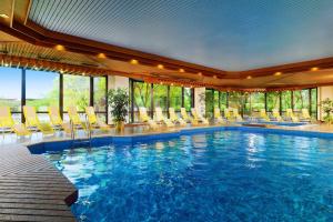 a large swimming pool with chairs in a hotel at Bilderberg Bellevue Hotel Dresden in Dresden
