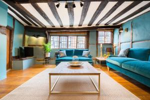a living room with blue couches and a coffee table at 3 MASONS COURT The Oldest House in Stratford Upon Avon, Warwickshire. in Stratford-upon-Avon
