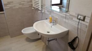 La salle de bains est pourvue d'un lavabo blanc et de toilettes. dans l'établissement Bonsai Bed & Breakfast, à Fiumicino