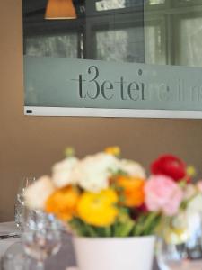 un vase de fleurs assis sur une table avec un signe dans l'établissement Ristorante Charme Hotel Tre Terre, à Ponte Brolla