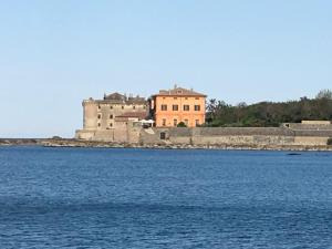 un castillo en la orilla de un cuerpo de agua en VILLA VENERE near the sea- 25 minutes to S.Peter, en Ladispoli