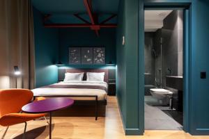 um quarto com uma cama e uma parede azul em Hotel Zeg em Tbilisi