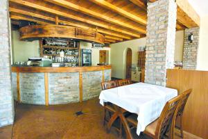 a dining room with a table and a bar at Hotel Kleopatra in Ulcinj