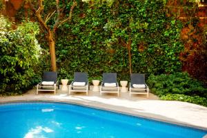 drei Stühle neben einem Swimmingpool in der Unterkunft Hotel Balmes, a member of Preferred Hotels & Resorts in Barcelona