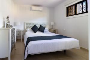 a bedroom with a large white bed with blue pillows at Paloma Beach Apartments in Los Cristianos